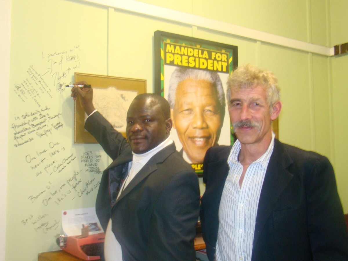 Signing the wall at Ikes Books. Dr Segun Ige and Prof Tim Quinlan