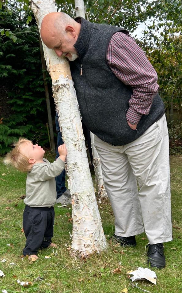 Ledger looking up at Alan, in front of a silver birch tree.
